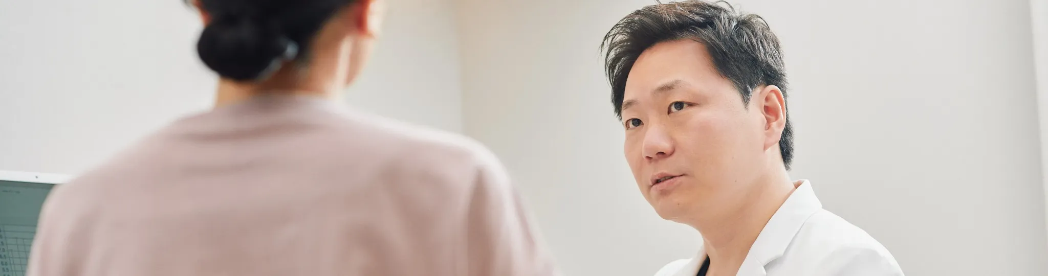 モニターのグラフを示しながら患者に説明する医師