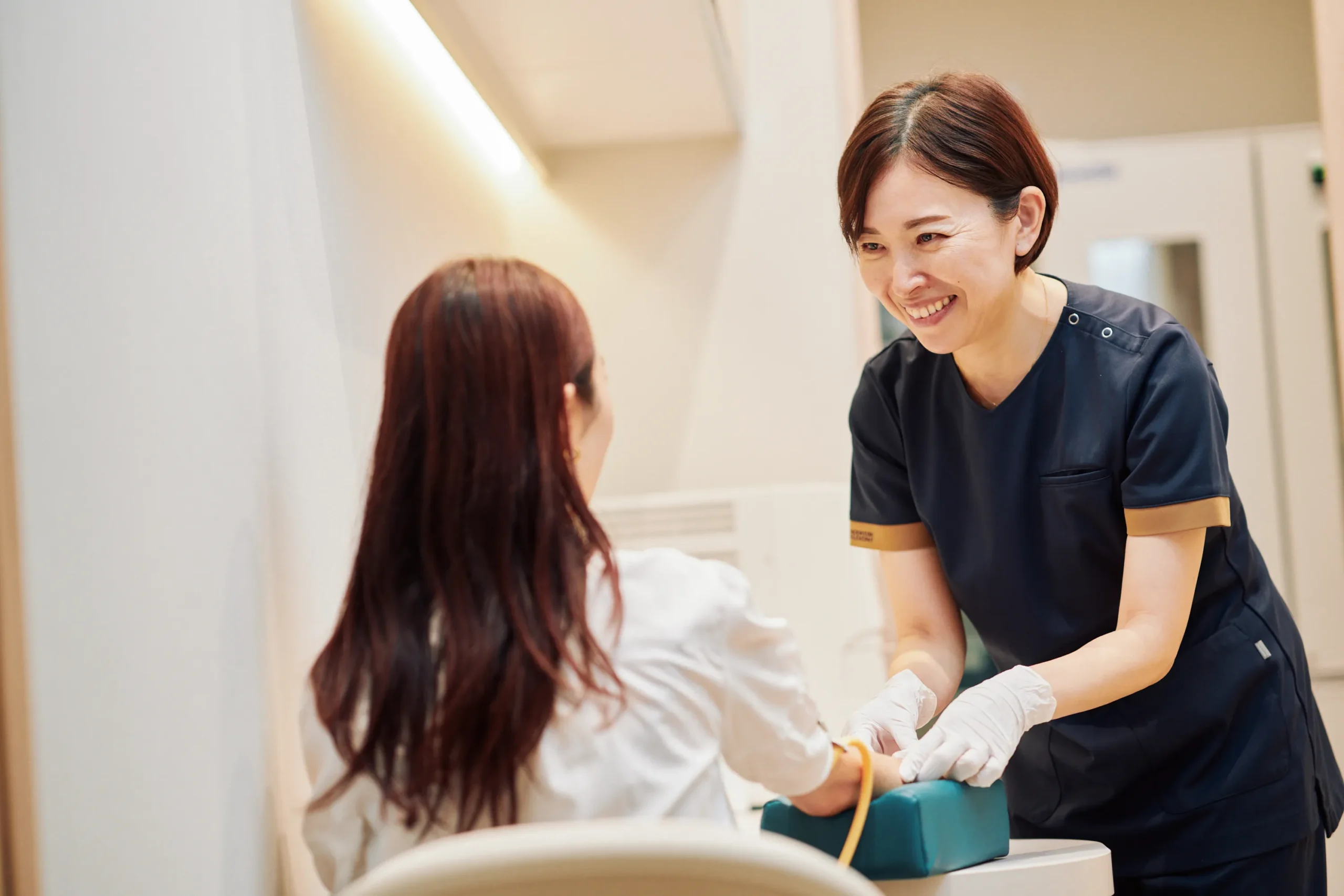 患者の腕に処置を行う看護師